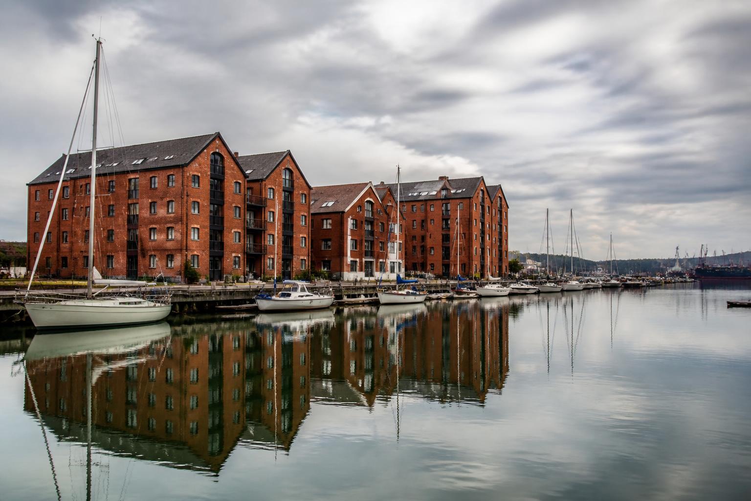 Historic red-brick warehouses and moored sailing yachts at Ipswich Waterfront marina, Suffolk
